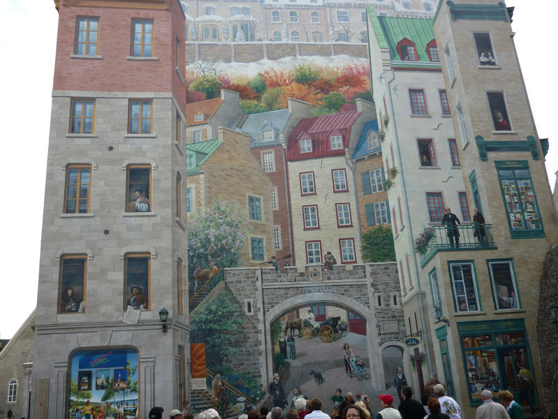 Trompe d'oeil painting, or three dimensional art using a technique of forced perspective, on a building with a group of tourists standing admiring it