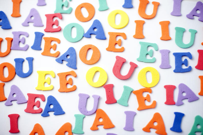 Colourful set of vowels randomly scattered on a white background for teaching kindergarten children to write, read, and spell