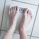 6897   Man weighing himself on a scale