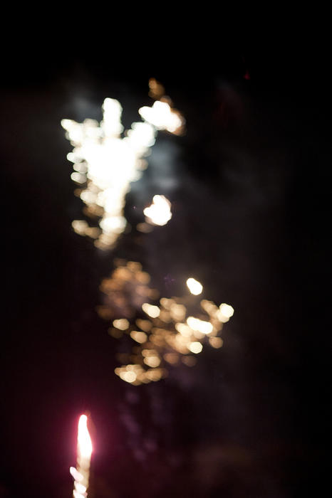 Abstract background of festive fireworks bursting in a colorful shower of sparks in a night sky, defocused blurred bokeh effect with copyspace