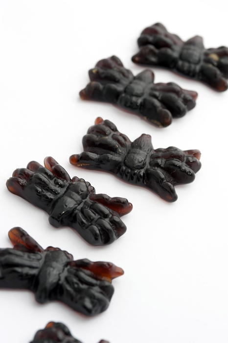 Detail of black scary Halloween jelly spiders on white for a fun trick-or-treating gift for young children