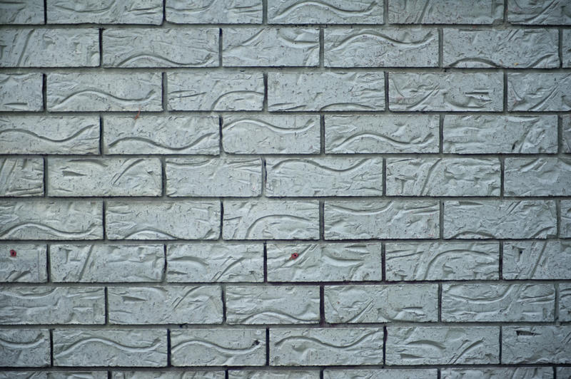 Background texture of ornamental grey bricks with an indented decorative pattern in a full frame background