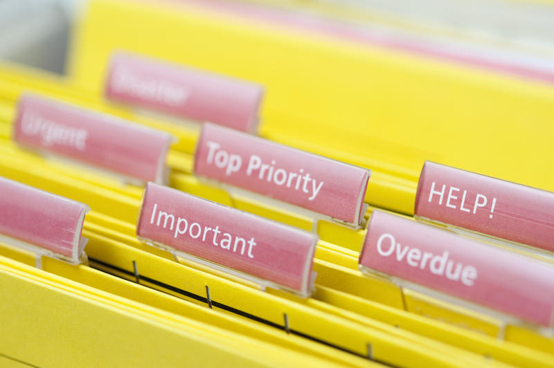 Busy Work Concept - Close up Files on Yellow Folders with Pink Labels Emphasizing Important, Overdue, Top Priority and Help Tasks.