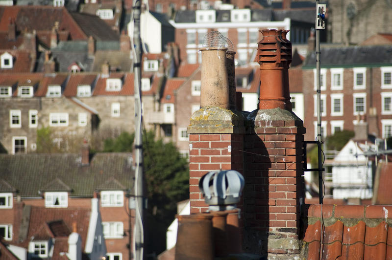 Rooftop view of different clay or earthenware chimney pots for increasing air flow and emitting smoke from domestic fires