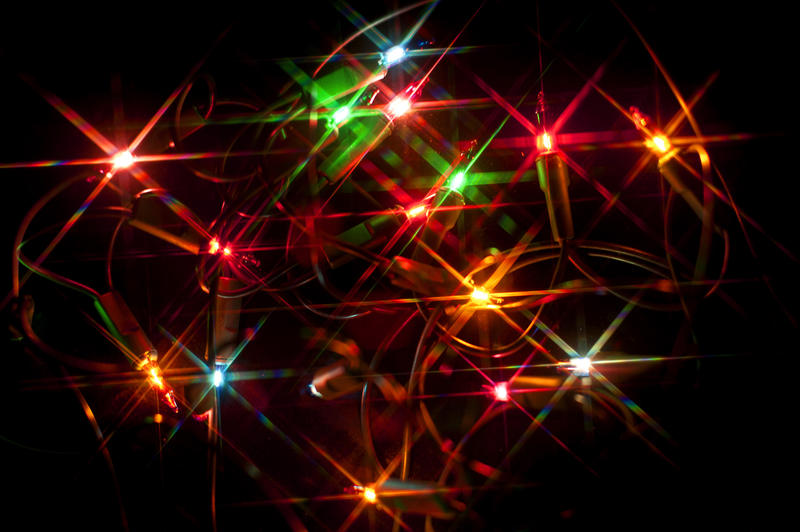 Colourful Christmas lights background with scattered multicoloured starbursts glowing brightly in the darkness
