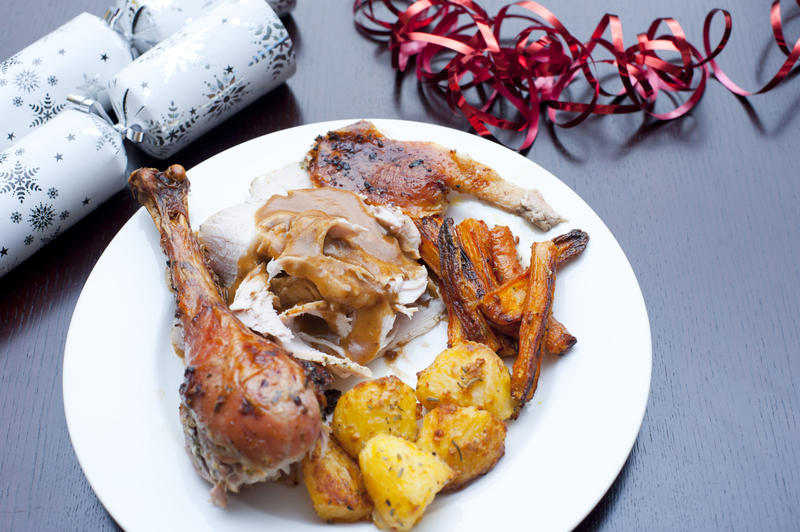 Serving of traditional Christmas dinner on a plate with portions of crispy brown roasted turkey with potatoes and carrots, high angle view