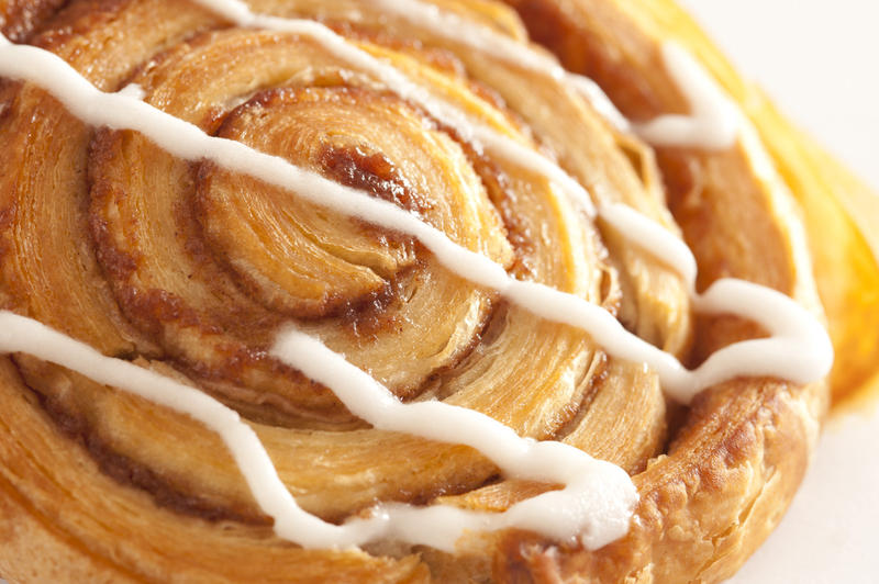 Close up of a traditional spiral freshly baked cinnamon Danish with apple filling for a tasty morning tea or coffee break