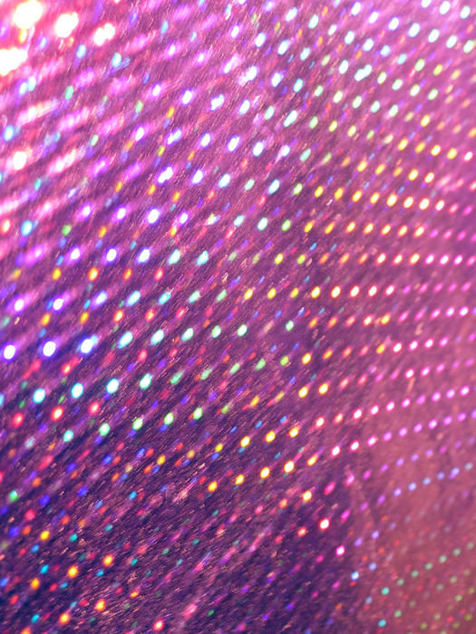 a motion blurred array of lights reflecting from a holographic foil surface