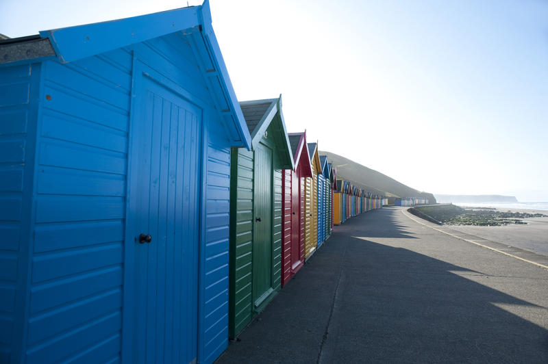 Coloured beach huts in Whitby West Cliff over the blue sky background