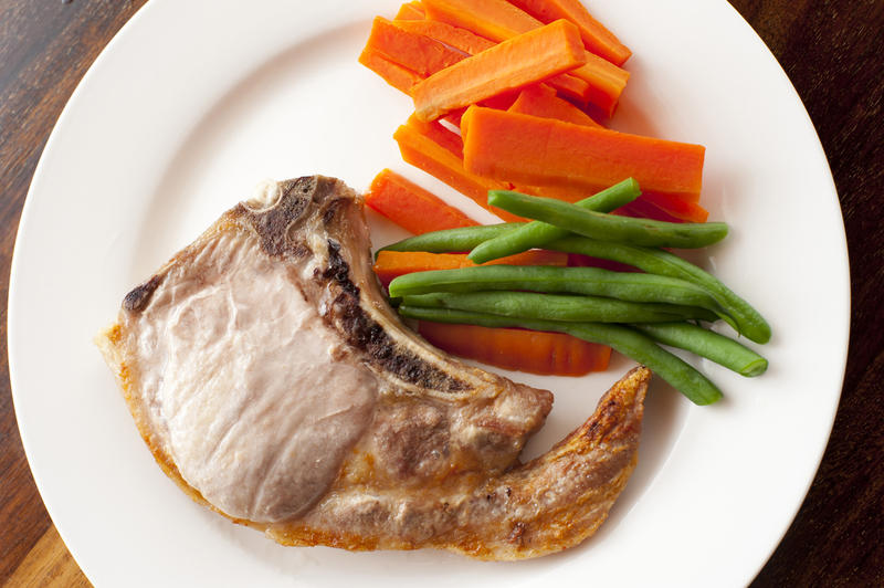 pork chopk with green beans and carrots. From above