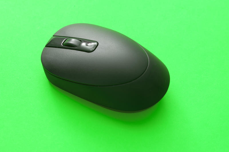 Close up Black Modern Cordless Computer Mouse Technology Isolated on Light Green Background