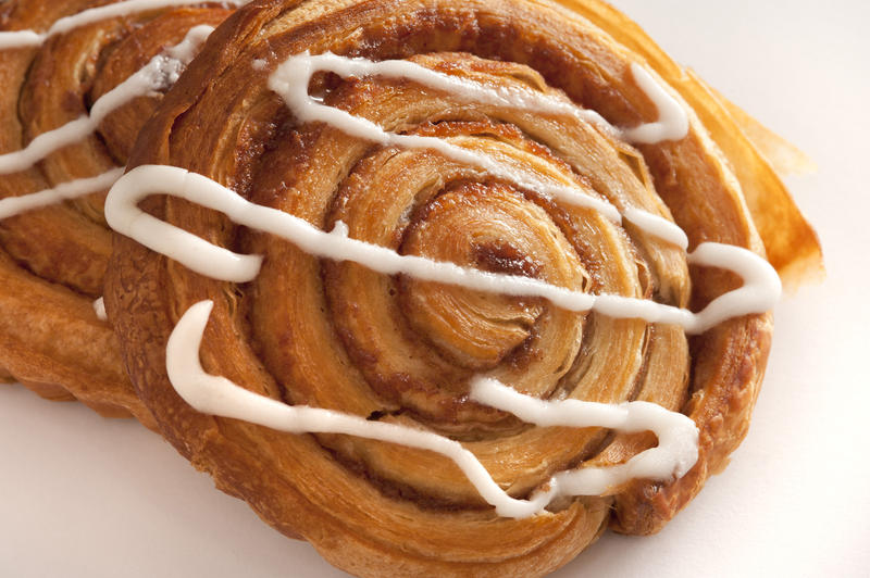 Delicious fresh cinnamon and apple Danish pastry with its traditional spiral pattern drizzled with white icing