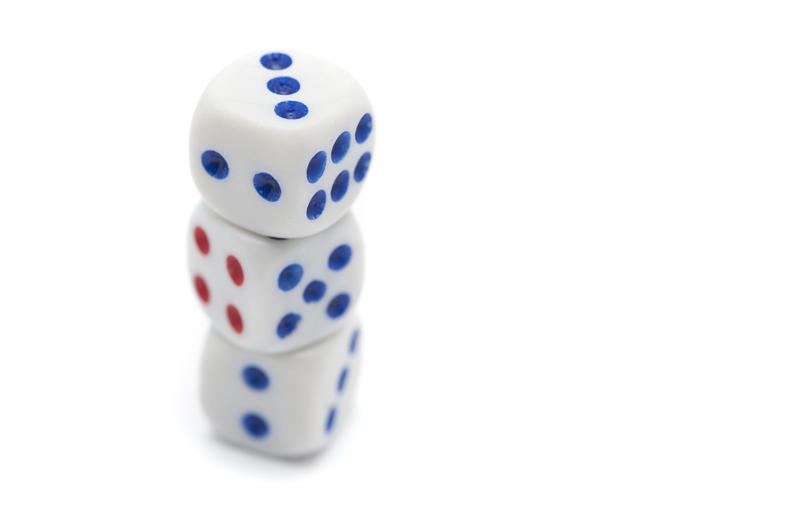 Three stacked white casino dice with blue dots for numbering for use in games of chance and gambling on white with copyspace