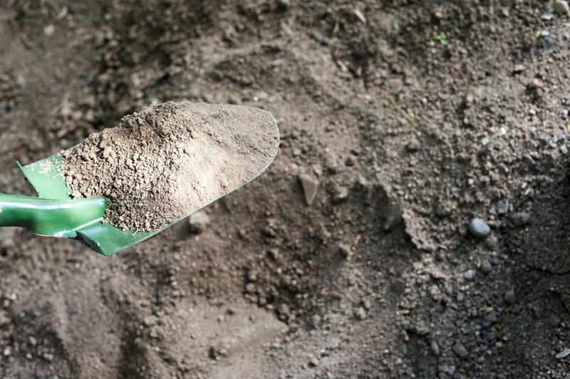 Digging over the soil in the garden with a spade or shovel - close up view of the blade