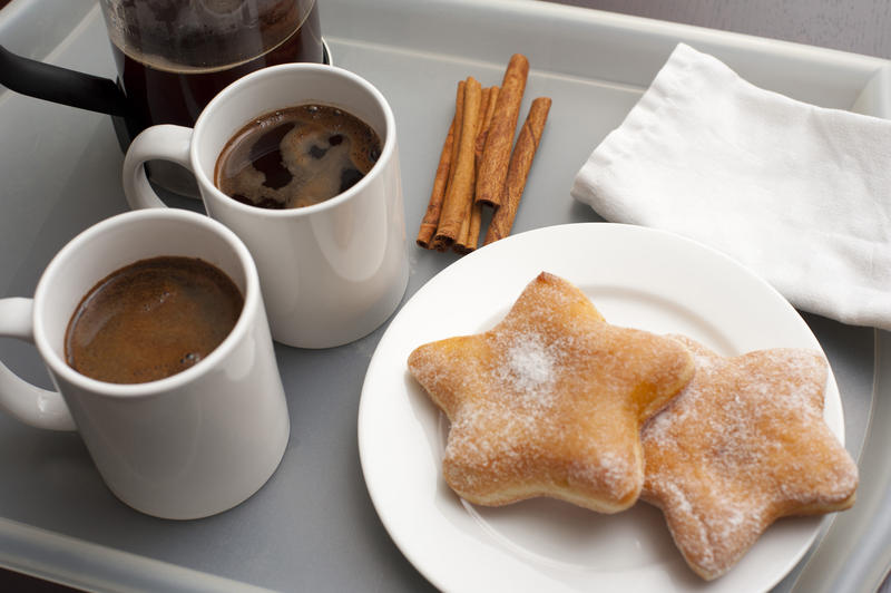 Breakfast on grey tray, two cookies, cinnamon and two cups of fresh hot coffee