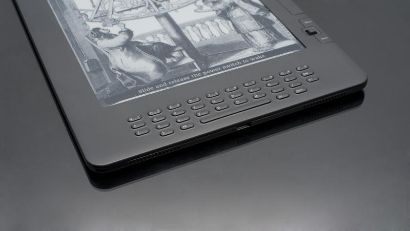 Close up High Tech Electronic Book Device on Top of Black Table, Emphasizing Copy Space.