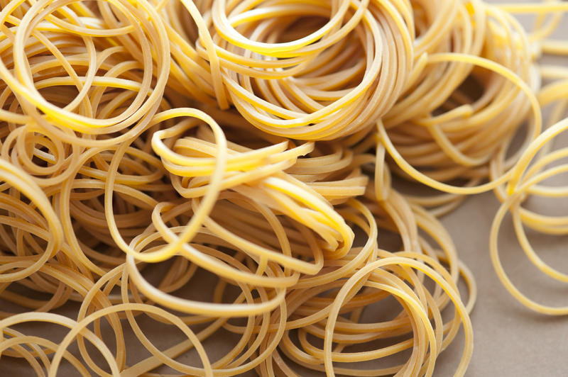 Close up Scattered Unused Yellow Elastic Rubber Bands on the Table