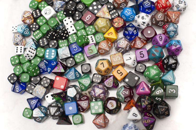 Assortment of Dice in Variety of Shape, Size, and Color from Board Games on White Background as seen from Above