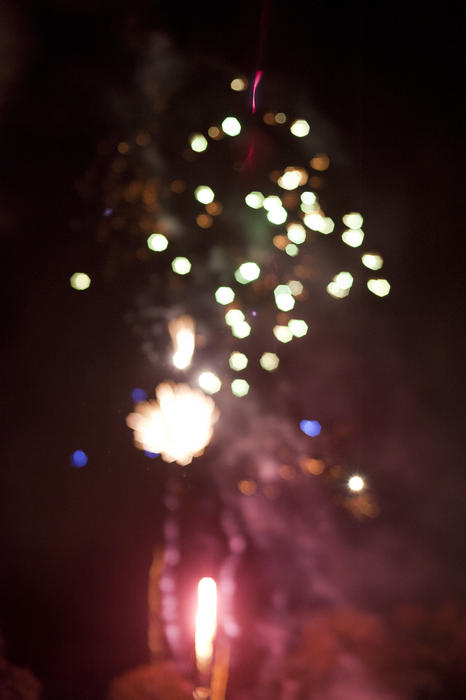 Background bokeh of colorful fireworks exploding in a shower of sparks in the night sky for a festive or holiday theme