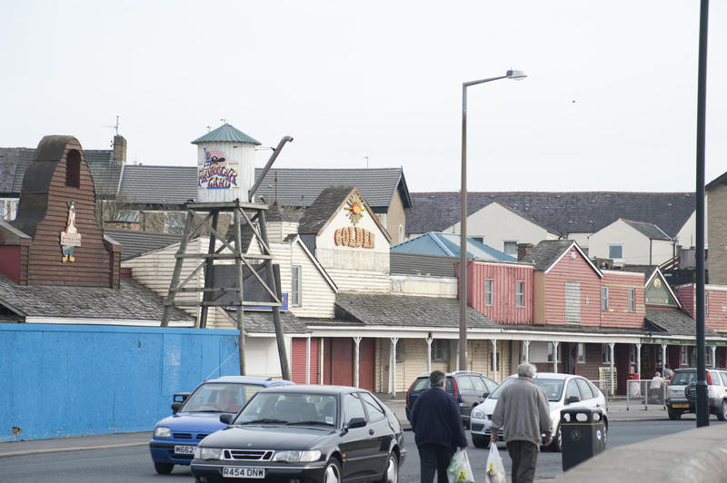 Derelict Frontierland Themepark in Morecambe in Lancashire seen from the street outside with traffic and pedestrians