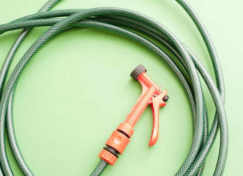 garden hose pipe and sprayer on a green backdrop
