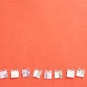 11406   Silver Gift Confetti in a Row on Orange Background