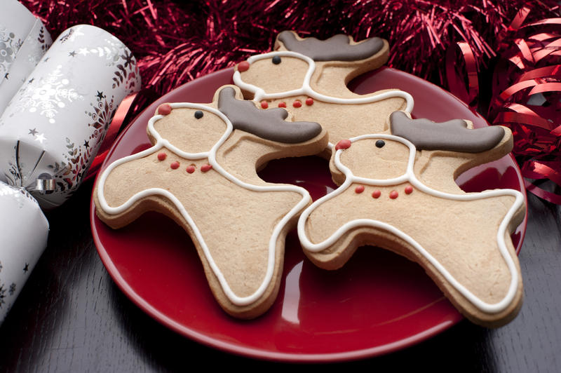 Gingerbread reindeer cookies with cute red noses and chocolate antlers on a festive table for a tasty Christmas teatime treat