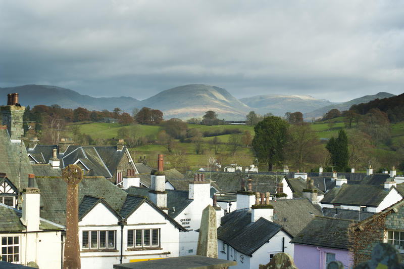 Hawkshead roofscape with a view across the quaint traditional whitewashed cottages to the scenic countryside of the Cumbrian Lake District beyond