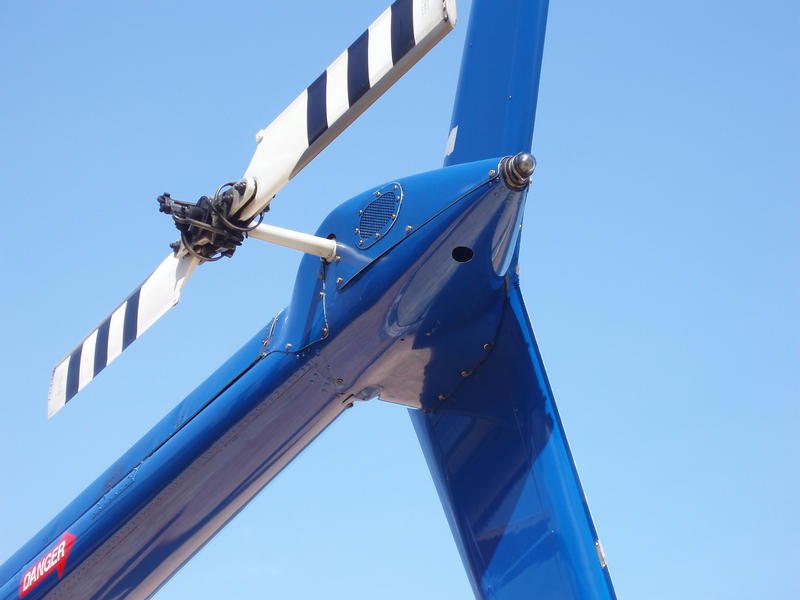 Close up Tail Rotor at the End of a Blue Helicopter Isolated on Sky Blue Background.