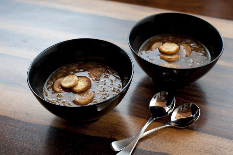 Two bowls of steaming hot french brown onion soup in bowls served as a starter and appetizer on a cold winter day