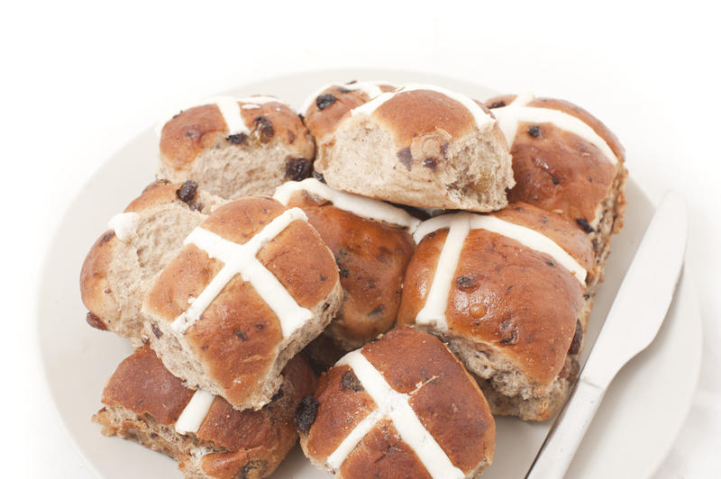 Close up Fresh Hot Cross Buns on a White Plate with Knife on the Side Isolated on White Background.