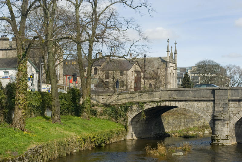 Picturesque old stone bridge over the Kent River at Kendall with a view of the historical stone church in the background