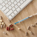 11551   Computer Keyboard and Syringe Surrounded by Pills