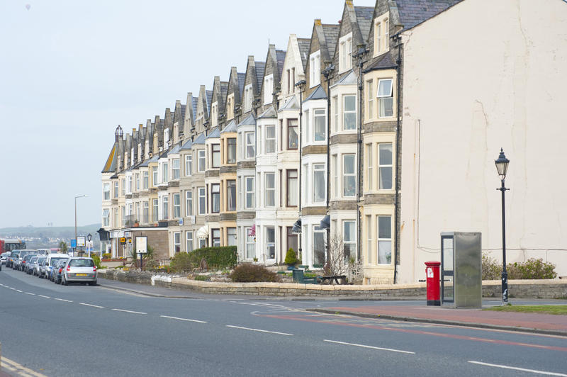 Exterior facade of multistorey seafront houses in Morecambe, Lancashire with bay windows as seen from the street below