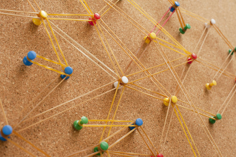 Network Concept Using Assorted Colored Pins on Cork Board Connected with Rubbers