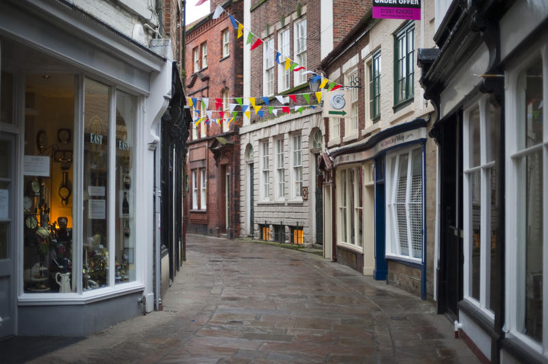 View of the narrow cobbled street and quaint old storefronts of Grape Lane in Whitby