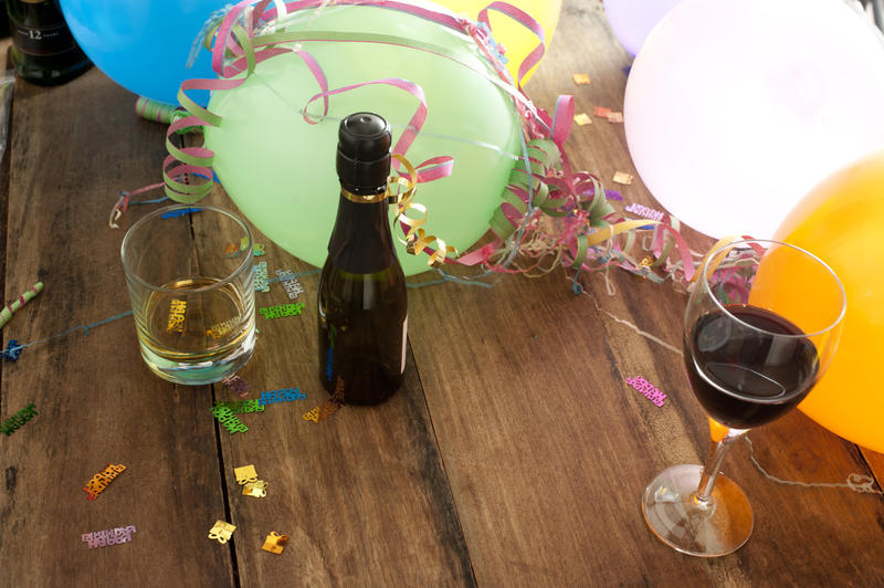 colourful balloons and drinks glasses with streamers on a table top,