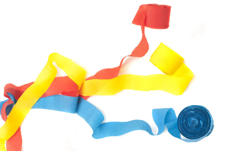 Three colorful party streamers in red, blue ad yellow isolated on a white background conceptual of a celebration, holiday or carnival