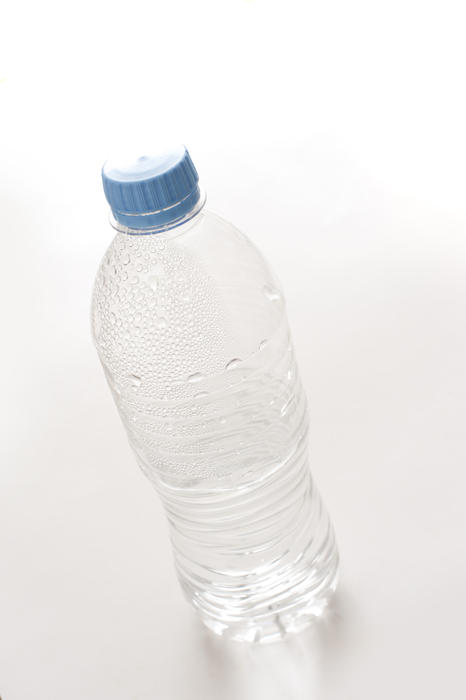 Empty unlabeled plastic water bottle with droplets still adhering to the sides in a healthy drinking and recycling concept