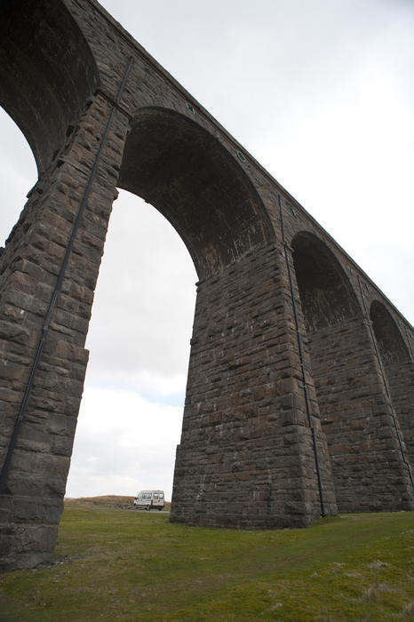 Low angle vie of the historical stone arches of the Ribblehead viaduct which is a railway viaduct across the valley of the River Ribble at Ribblehead, in North Yorkshire
