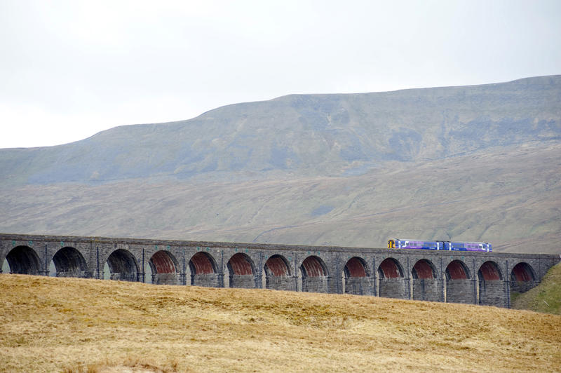 View of a train crossing the Ribblehead viaduct, a Victorian railway viaduct crossing the River Ribble in North Yorkshire