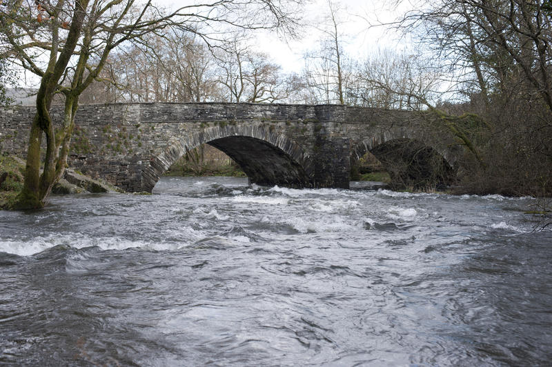 View looking upstream over fast flowing water of Skelwith Bridge and the Skelwith River in the Lake District in Cumbria