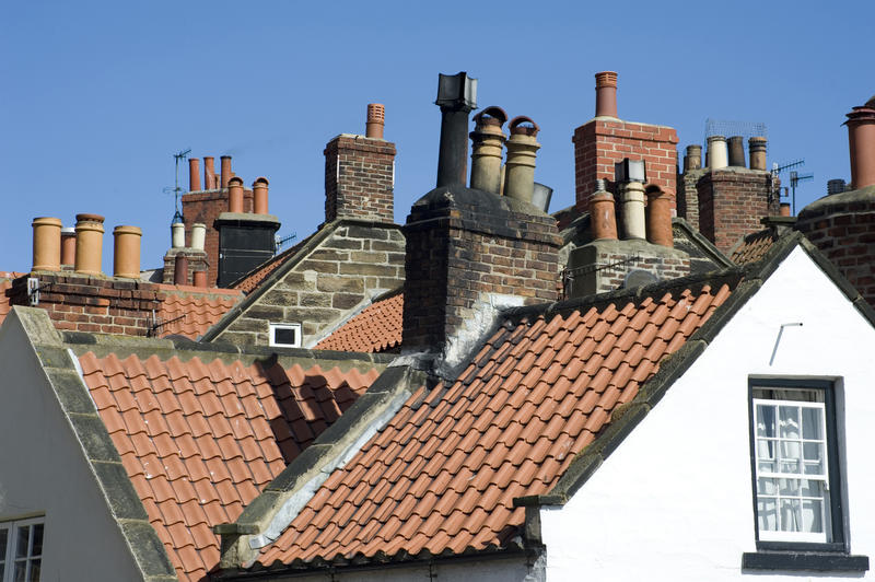 View of red tiled rooftops and a variety of different chimney pots in a typical English village