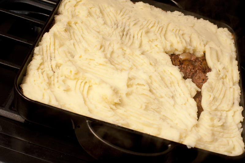 Baking dish with Shepherds pie made of minced or chopped meat, usually beef, topped with a crust of mashed potato