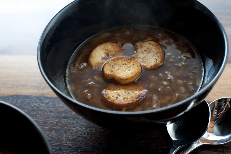 Crisp golden fried croutons floating in a bowl of brown French onion soup