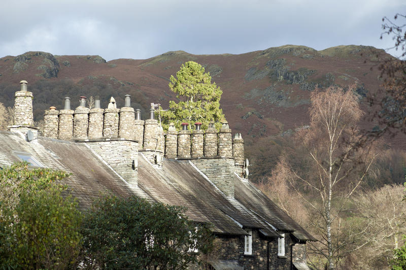 Row of Cumbrian stone cottages at Skelwith Bridge in the Lake District with quaint traditional cylindrical stone chimney pots