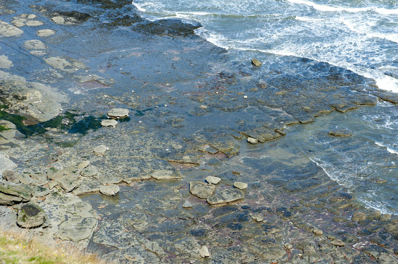 Stone pavement composed of slabs of granite washed by the ocean tides at the coast at Robin Hoods Bay