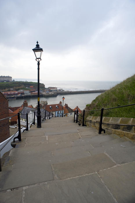 View looking down at the town and ocean from the 199 Church steps in Whitby leading from the town up Tate Hill to St Marys church
