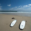11002   Two surfboards lying on a beach