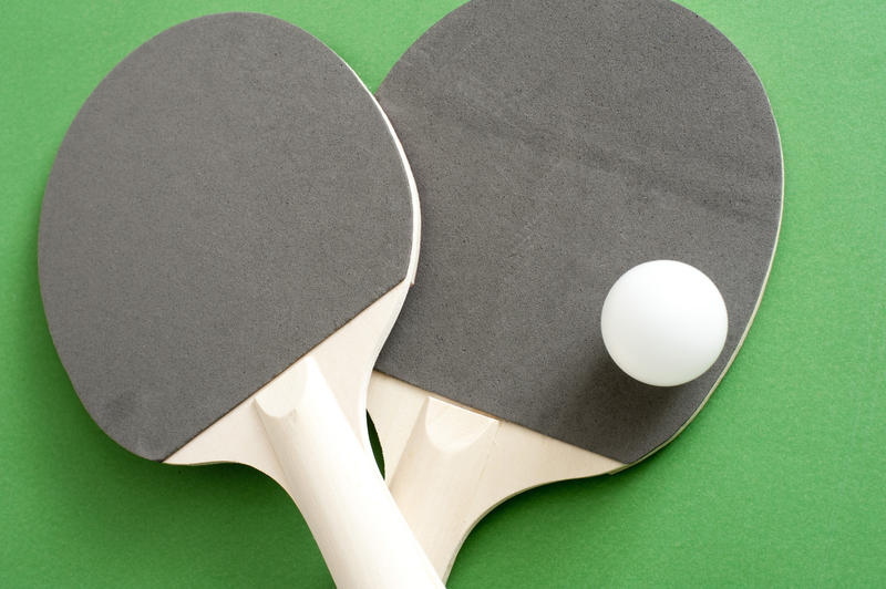 Close up Gray and White Rackets with One White Ball for Table Tennis Sports, Isolated on Green Background.